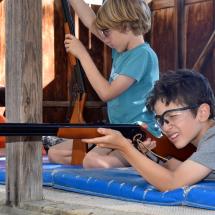 younger campers shoot air rifles at camp