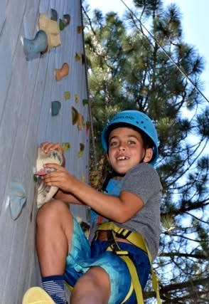 Boy on a climbing wall at summer camp