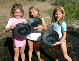 Girls holding gold pans at summer camp